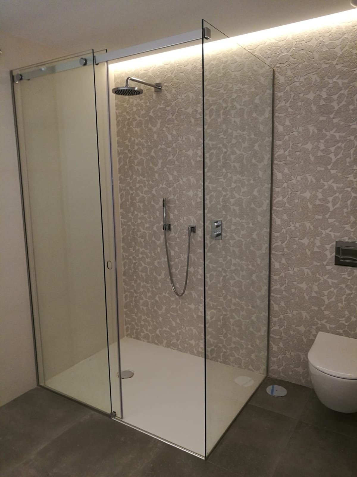 Un baño con ducha a ras de suelo y un inodoro.