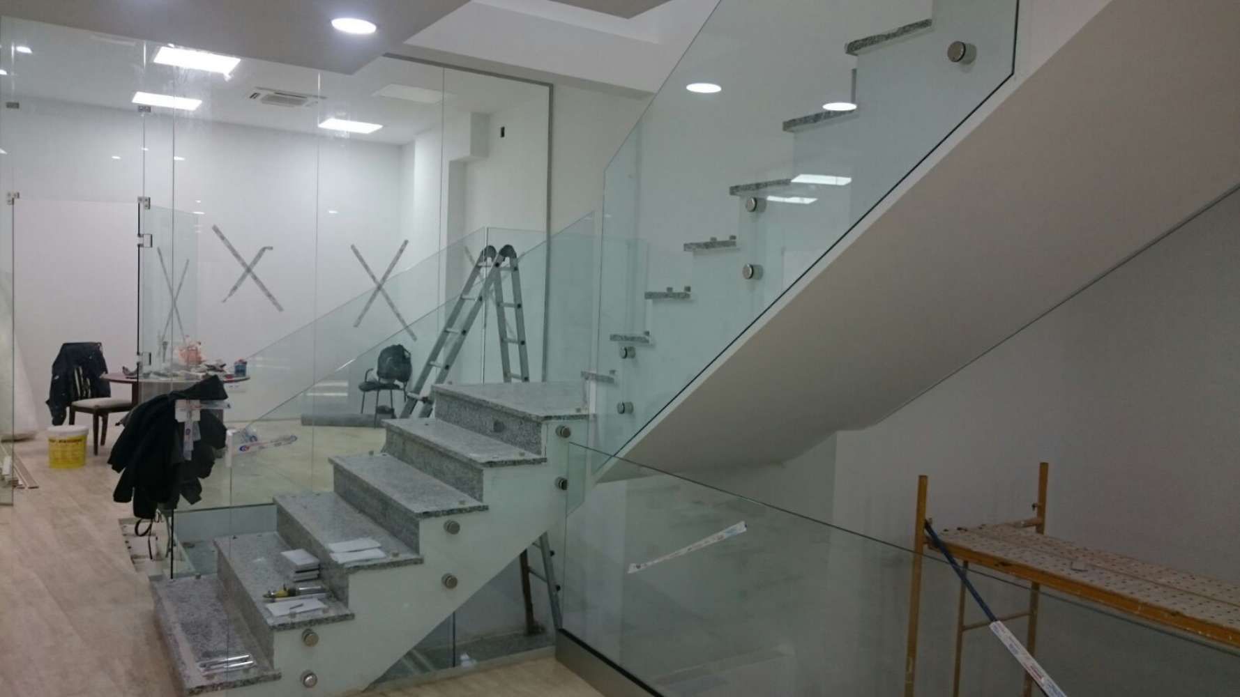 Se está construyendo una escalera con barandilla de cristal en un edificio.