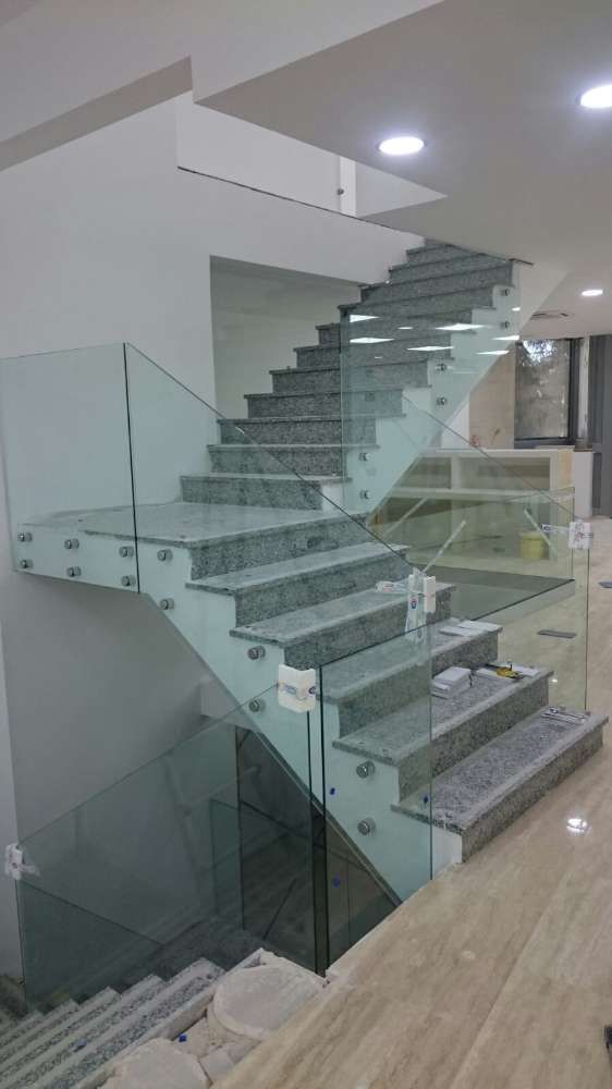 Una escalera con barandilla de cristal en una casa.