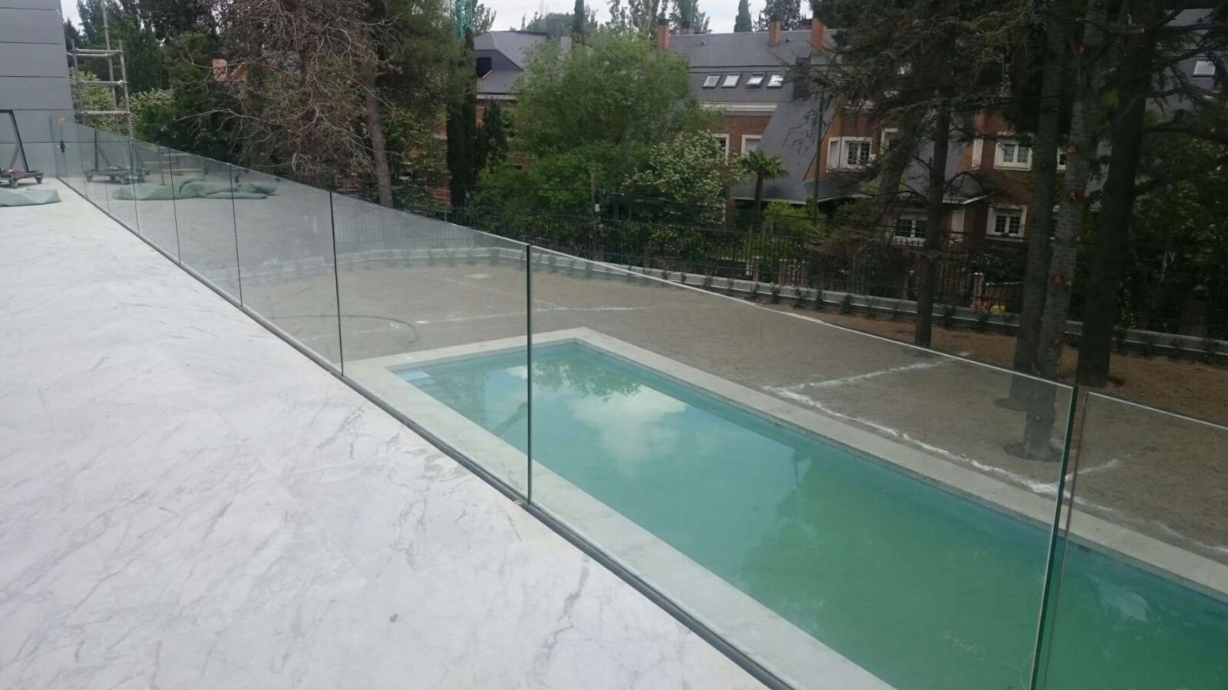 Una piscina con una valla de cristal a su alrededor.