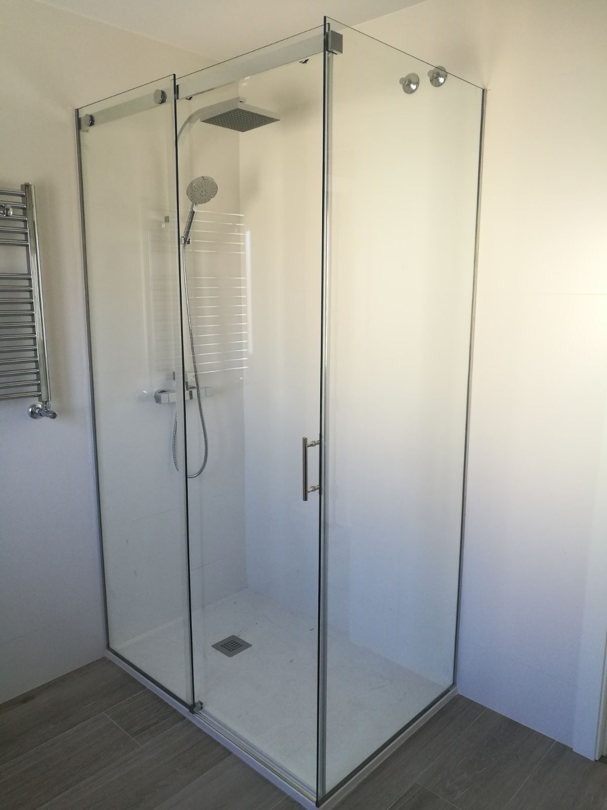 Una cabina de ducha con puertas corredizas de vidrio en un baño.