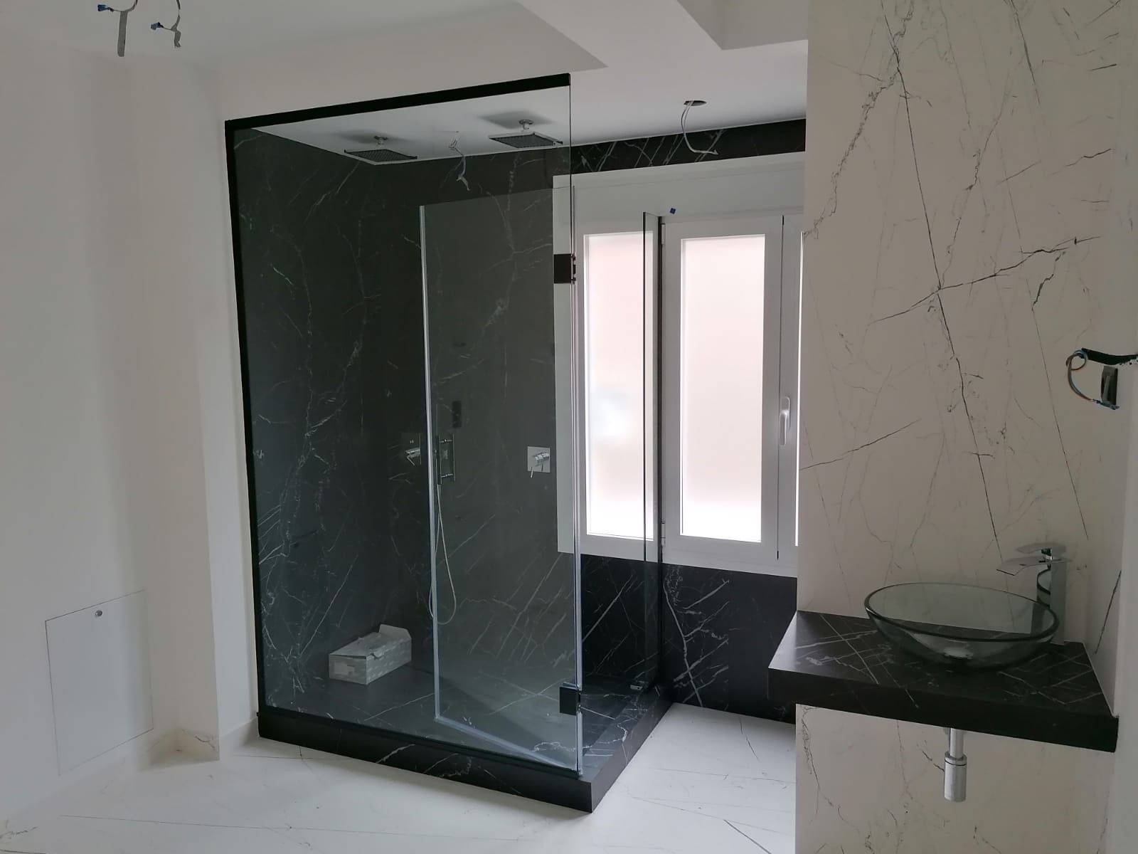 Un baño con ducha a ras de suelo y lavabo.