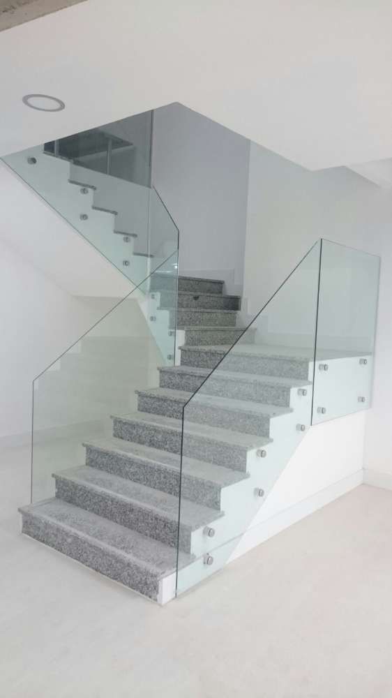 Una escalera con barandilla de cristal en una casa.