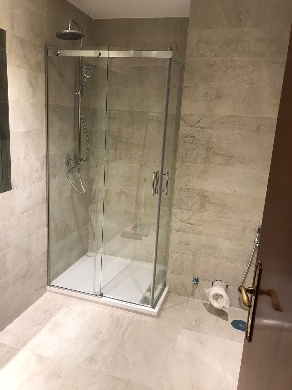 Un baño con ducha a ras de suelo y un inodoro.