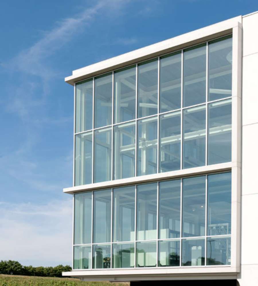 Un gran edificio blanco con muchas ventanas contra un cielo azul.