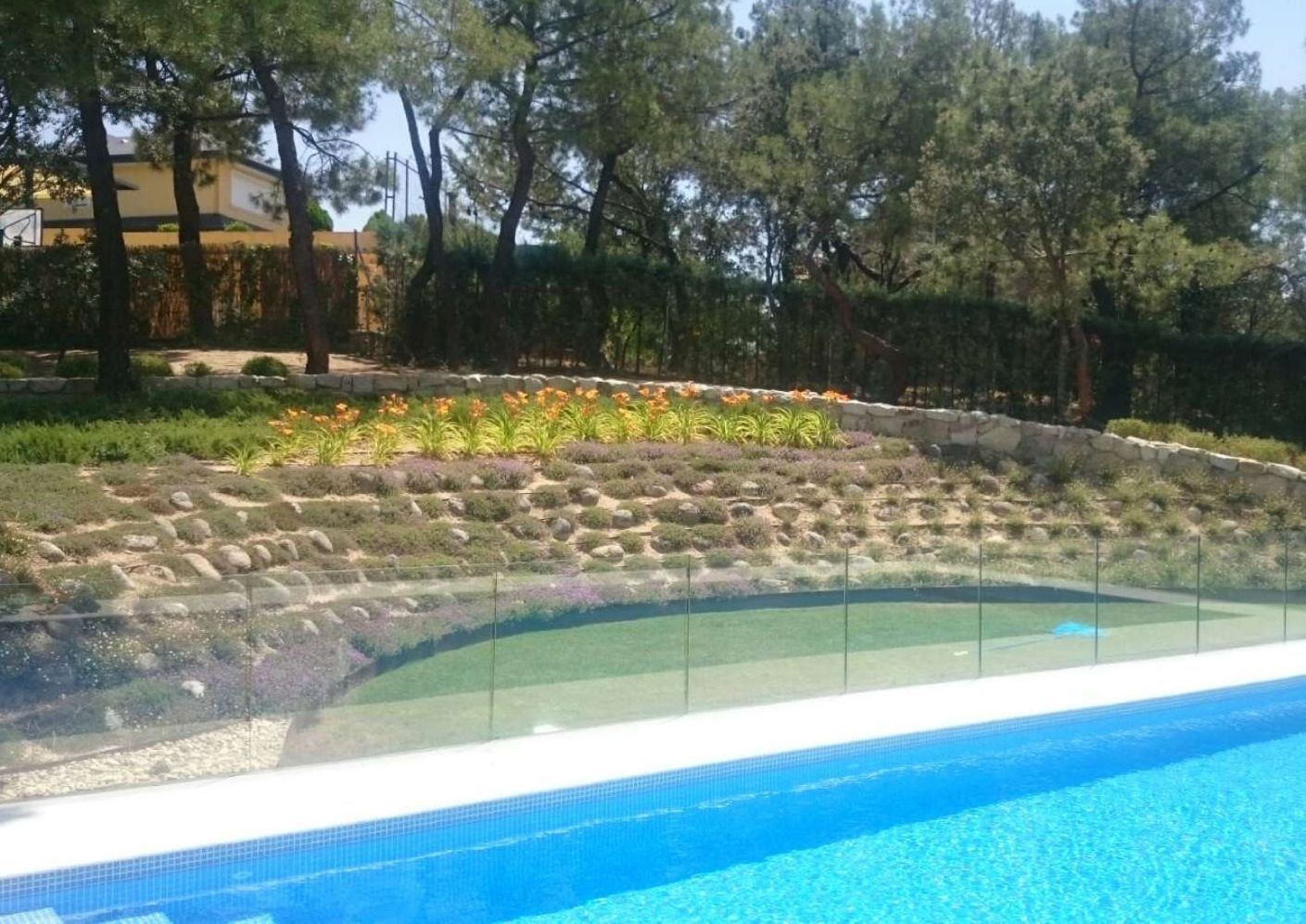 Una piscina con una valla de cristal a su alrededor.