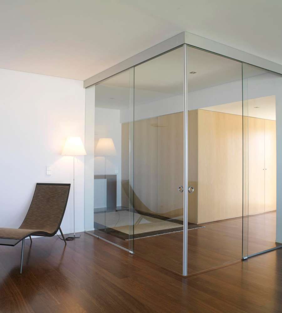Una sala de estar con una silla y una pared de cristal.