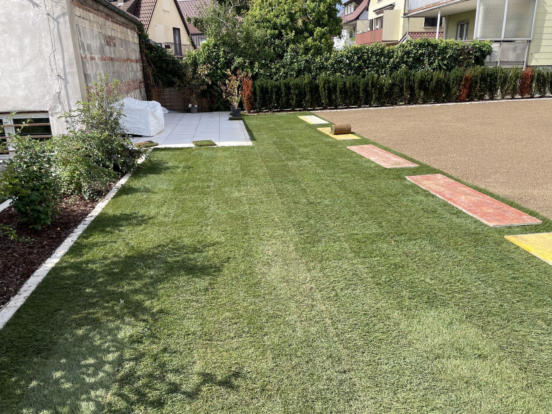 Neu angelegter Gartenweg mit Rasen und Beeteinfassung.