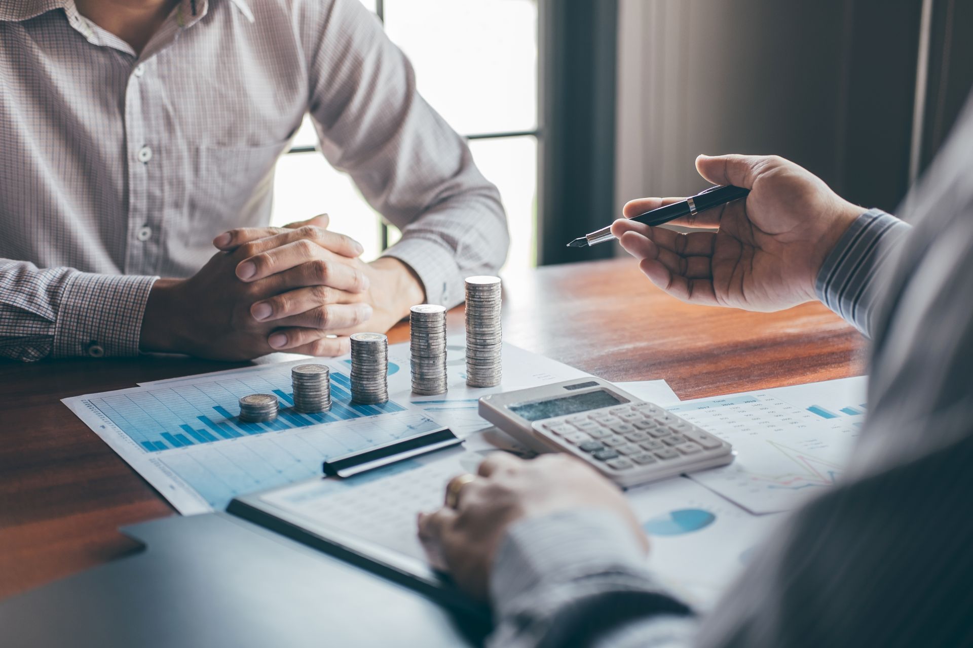 Stapel von Münzen auf Papier mit Statistiken
