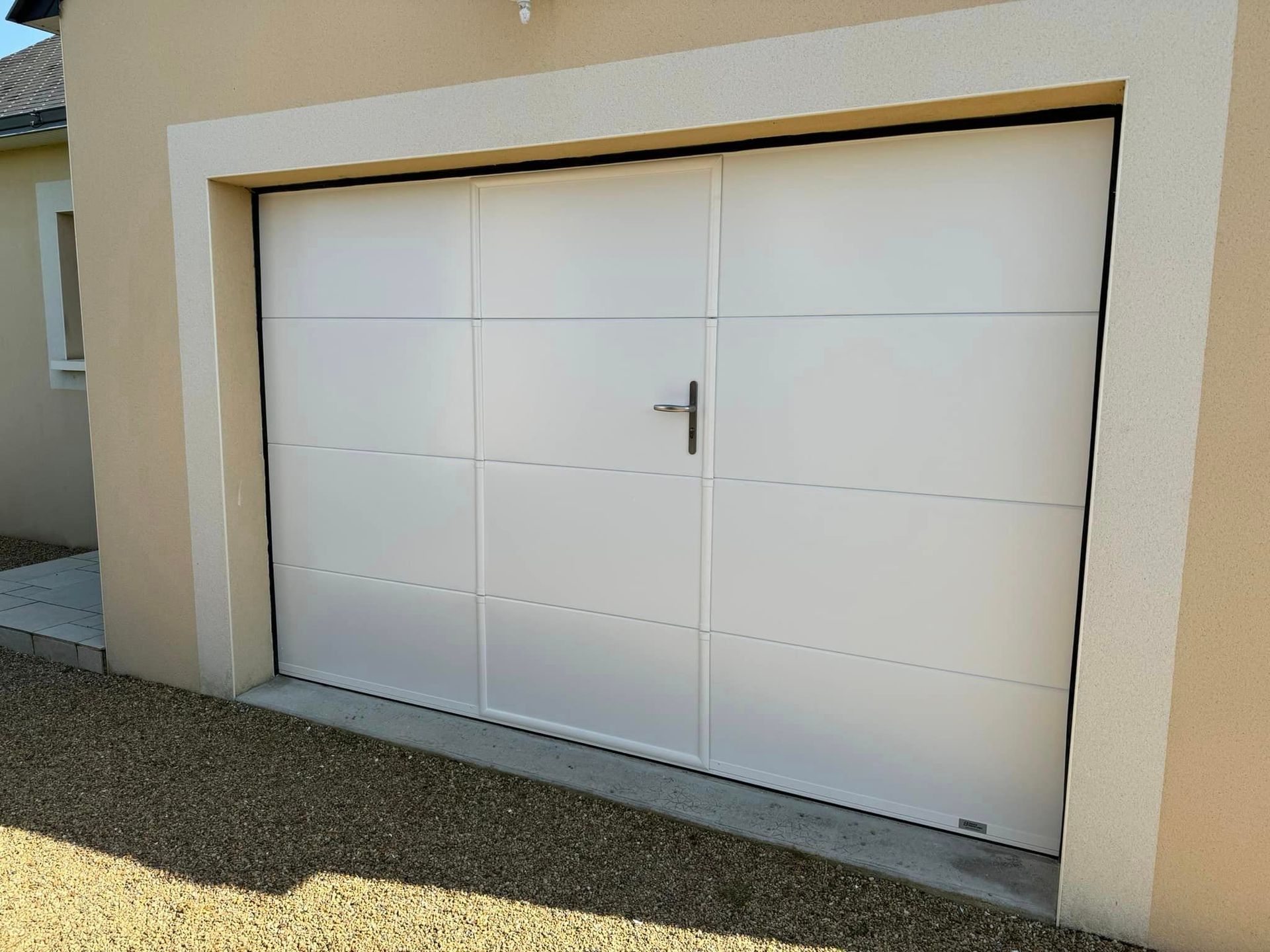 Porte de garage sectionnelle blanche prise de l'extérieur