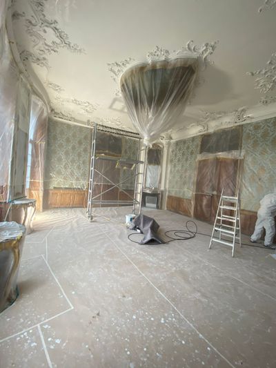 Raum im Umbau mit Gerüst, Plastikplanen und Arbeitern.