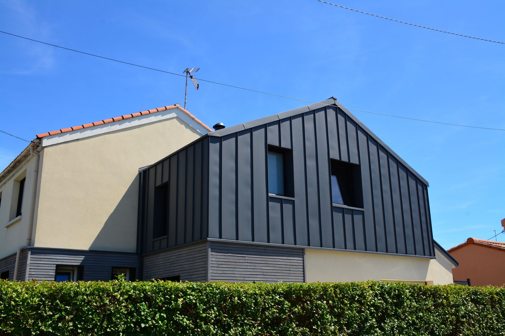 Un bardage métalliques de couleur gris anthracite.