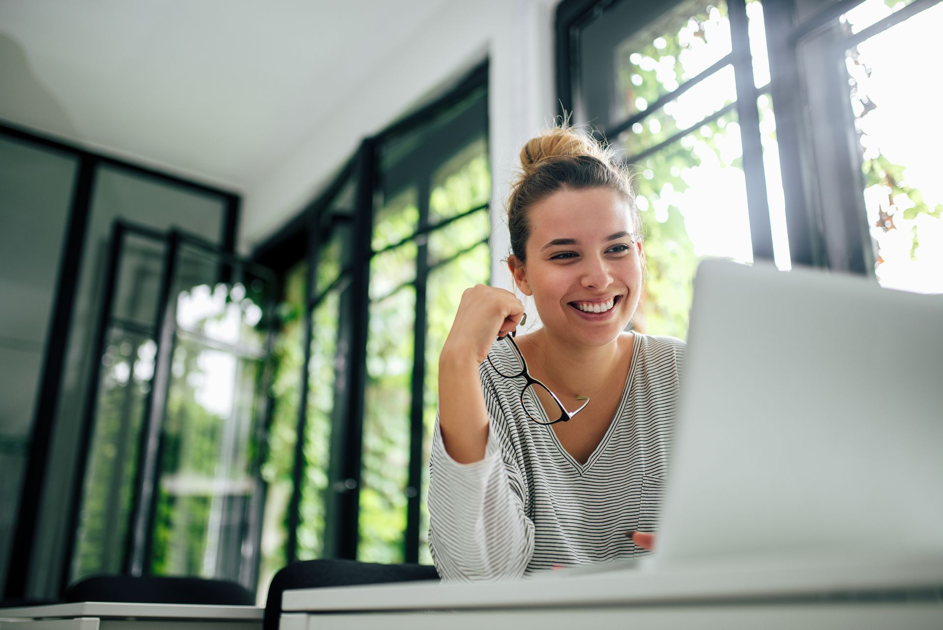 Une femme qui travaille en souriant.