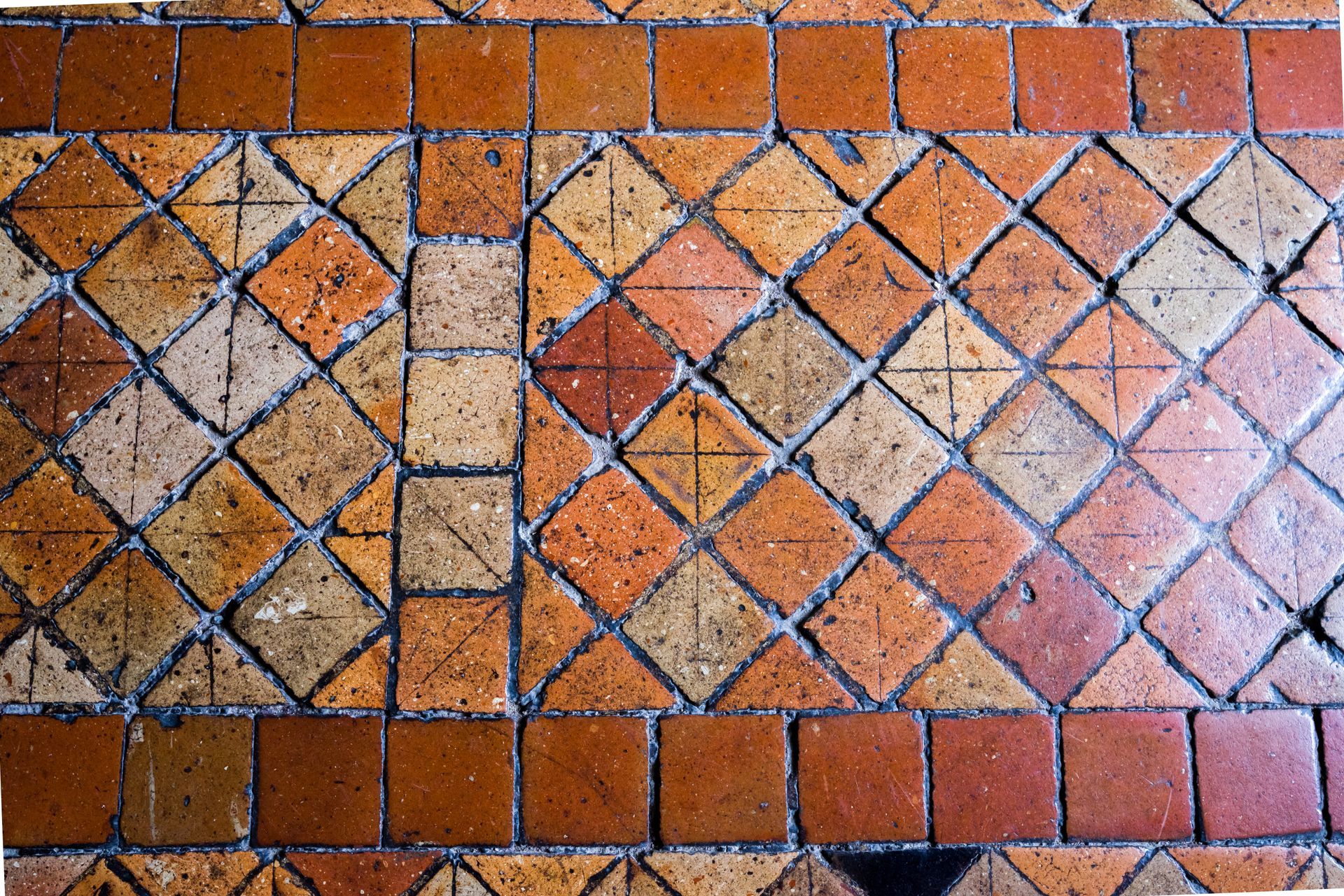 Un sol dont les tomettes sont abîmées.