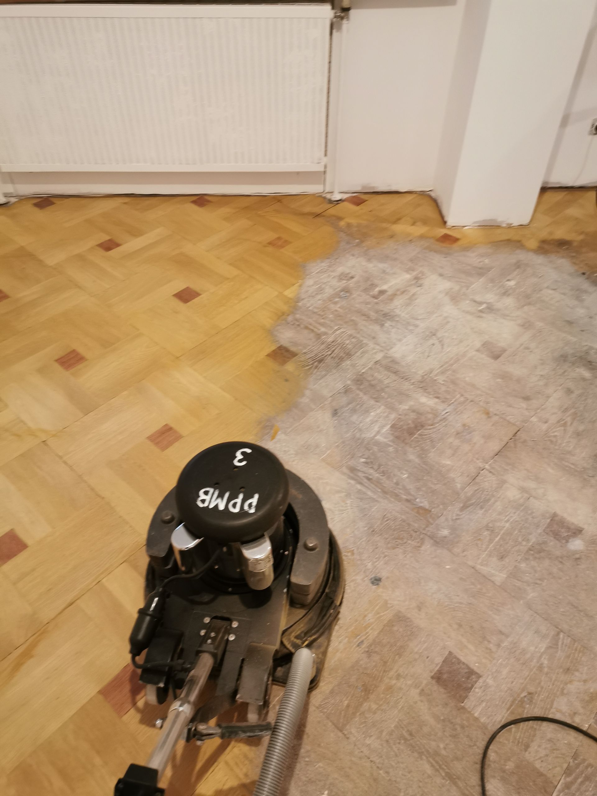 Un ponçage de parquet à l'aide d'une machine professionnelle.