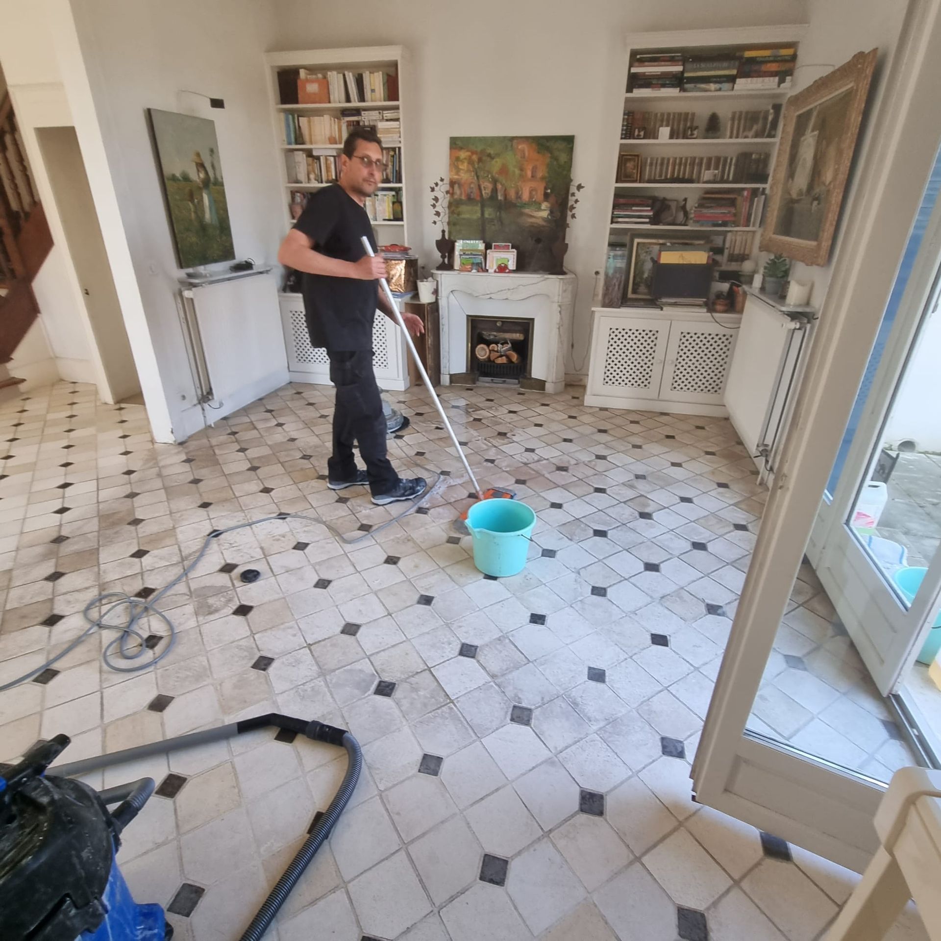 Un homme qui nettoie un sol dans une maison.