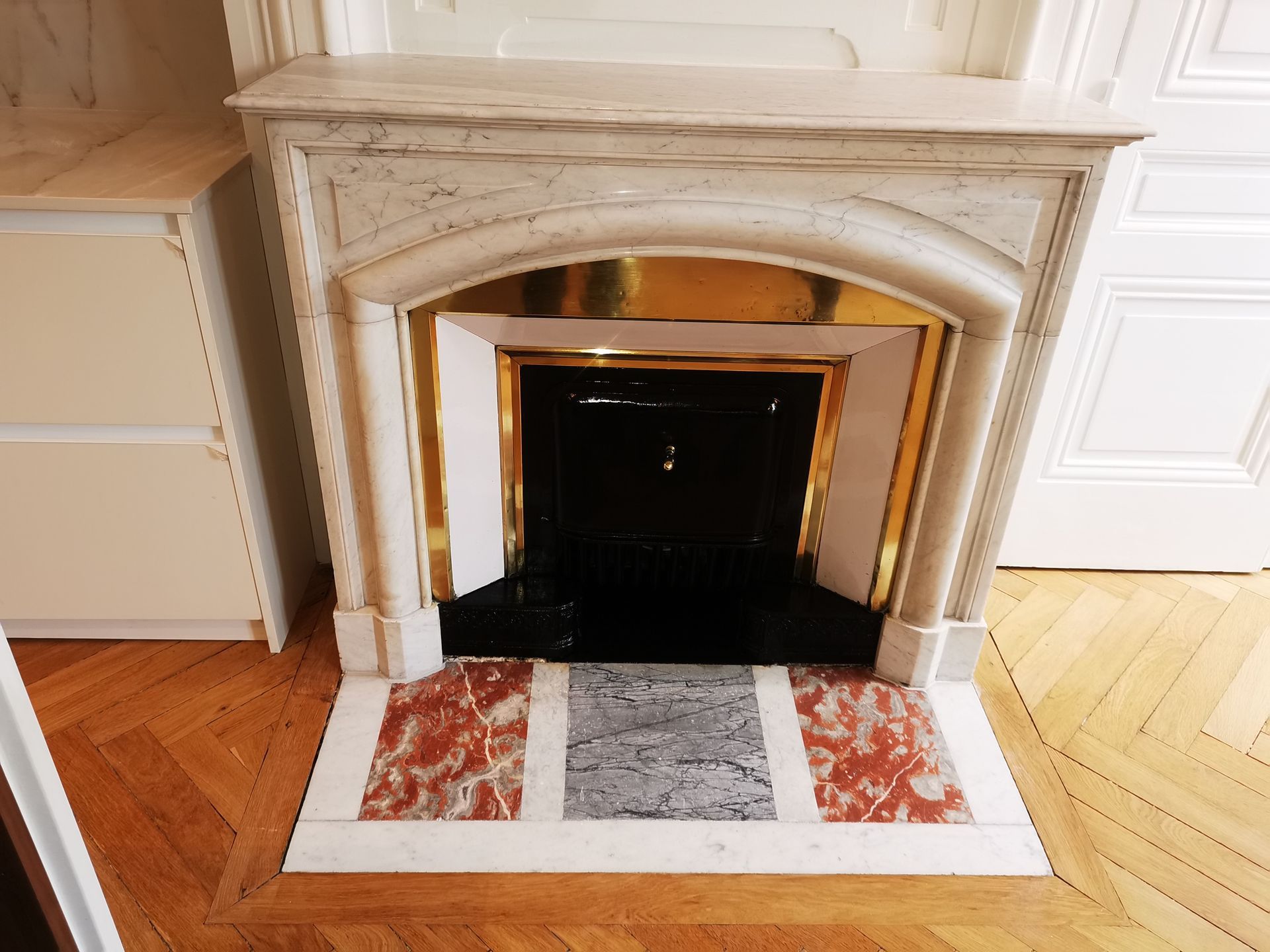 Une cheminée dont le contour est fait de marbre.