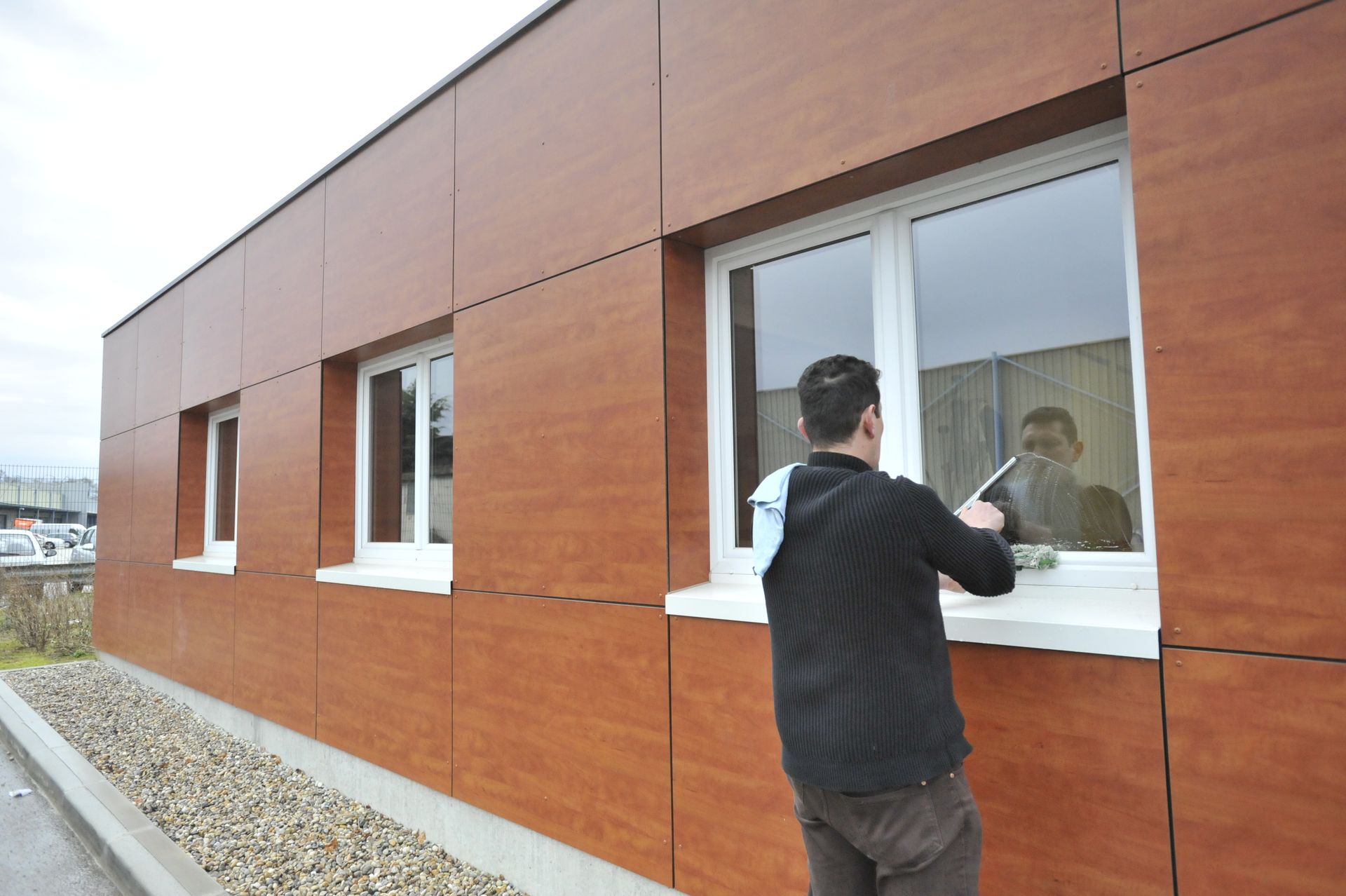 Un homme qui lave les vitres d'un local.