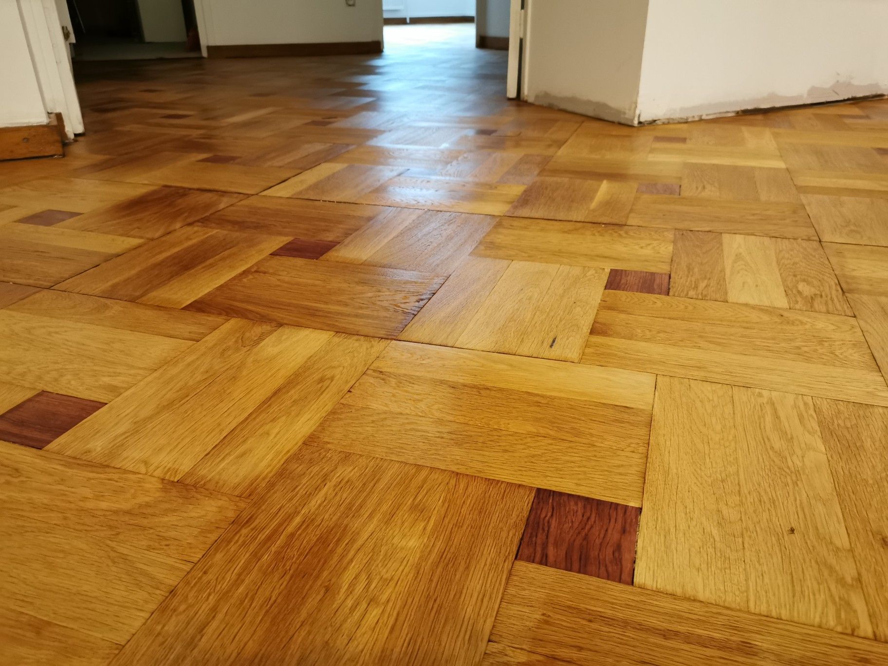 Une personne qui applique du cirage sur un parquet.