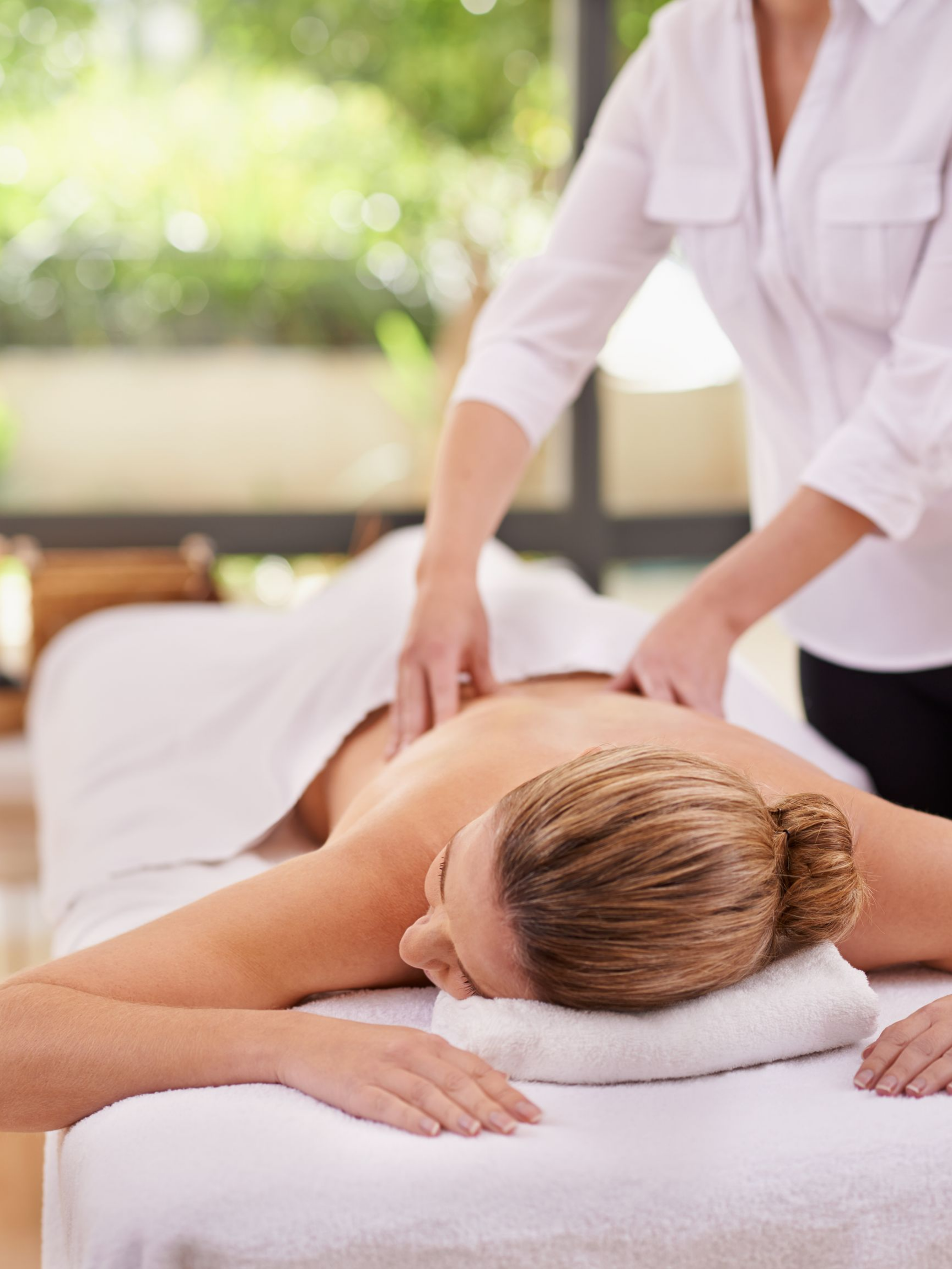 Une femme reçoit un massage du dos dans un spa.