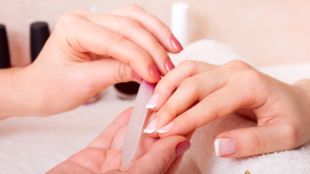 Main d'une personne manucurée à la lime à ongles.
