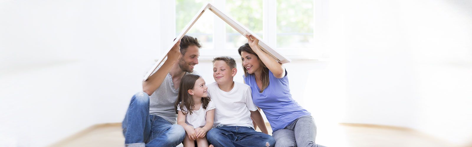 Eine Familie sitzt unter einem Papphaus.