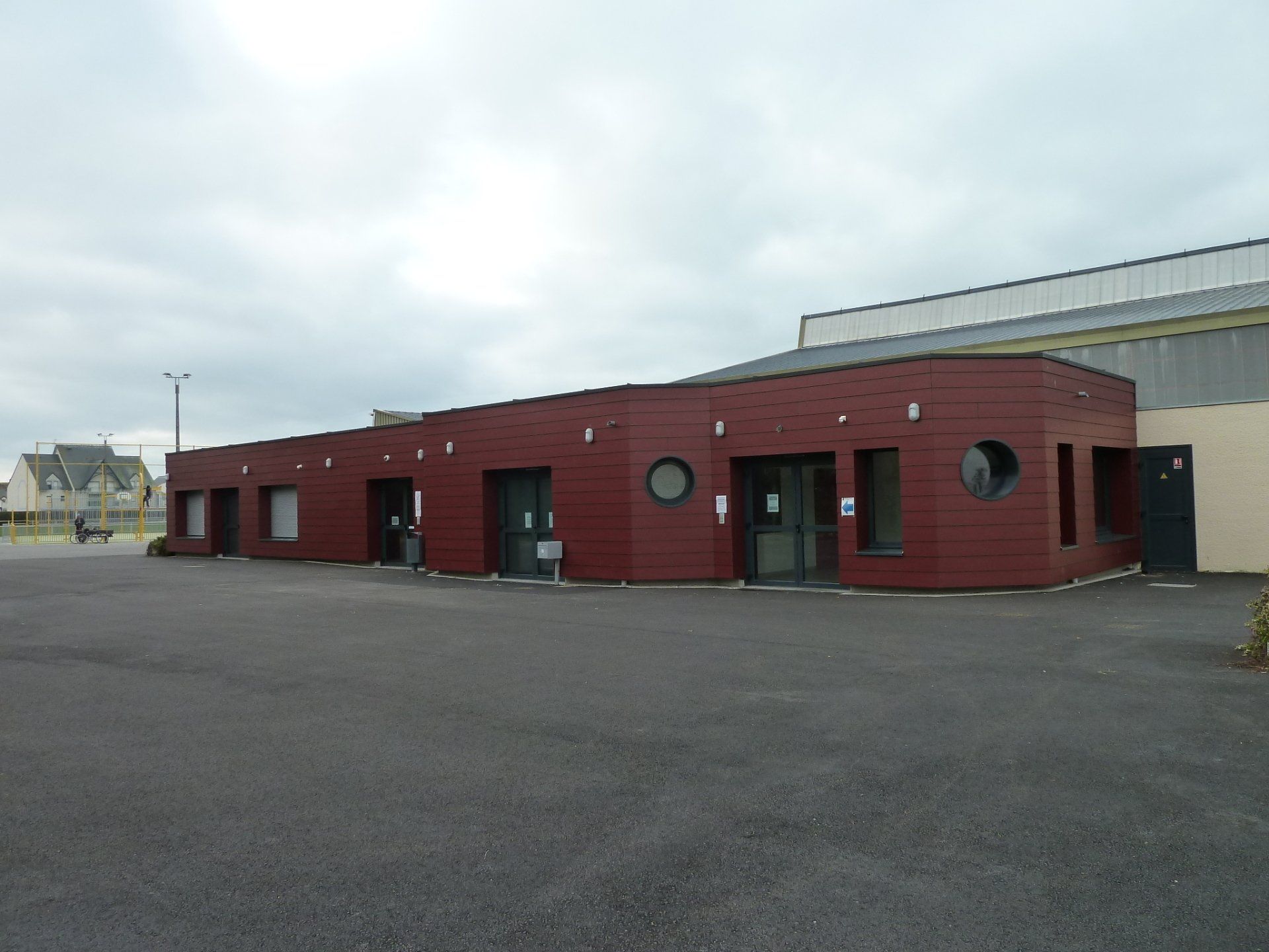 Bâtiment rouge bordeaux avec de nombreuses fenêtres rondes