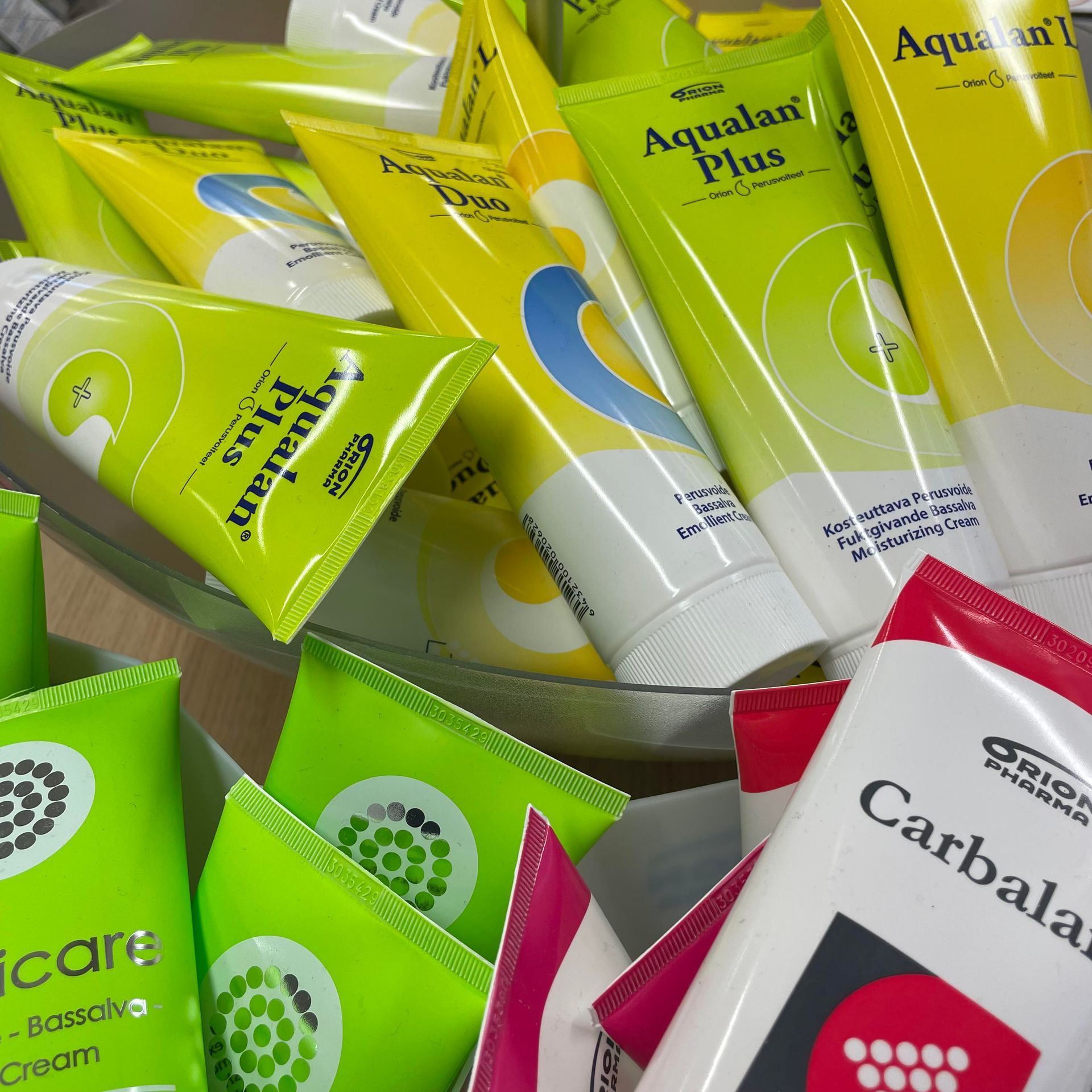 Aqualan Plus -voidetta ja muita vastaavia tuotteita sisältävät tuubit on järjestetty telineeseen.