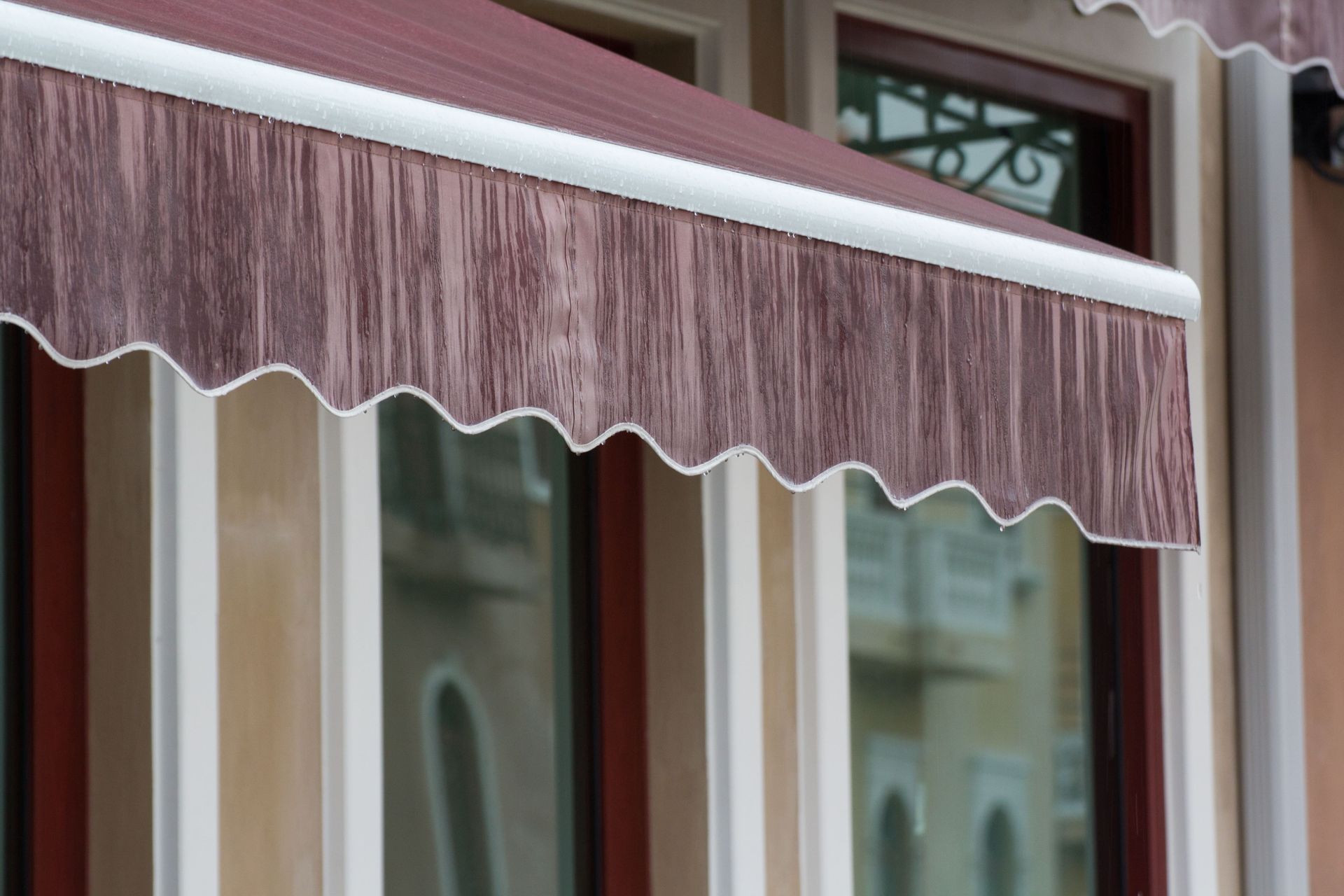 Una ventana con un toldo rojo encima.