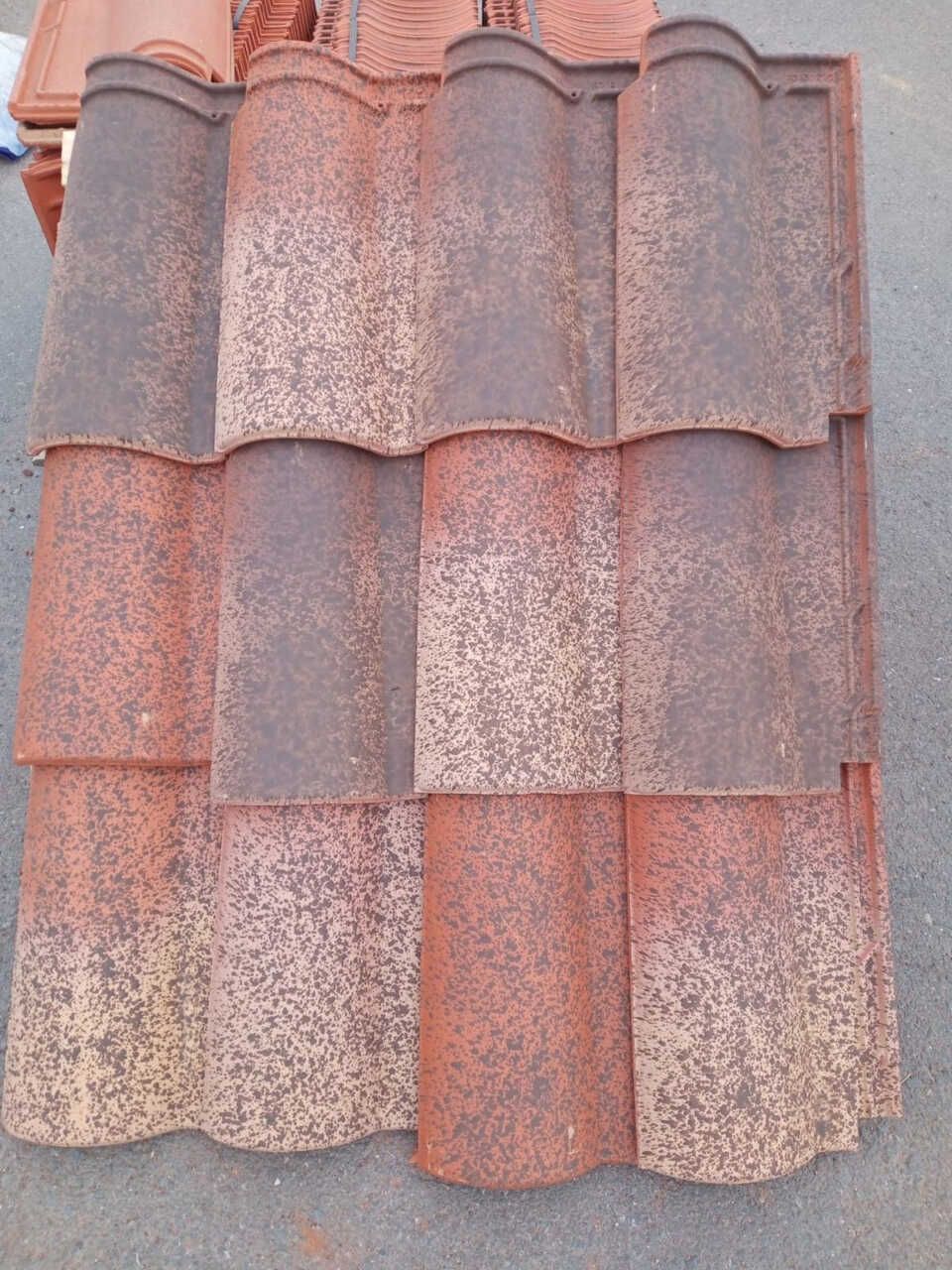 Una hilera de tejas rojas están apiladas una encima de otra