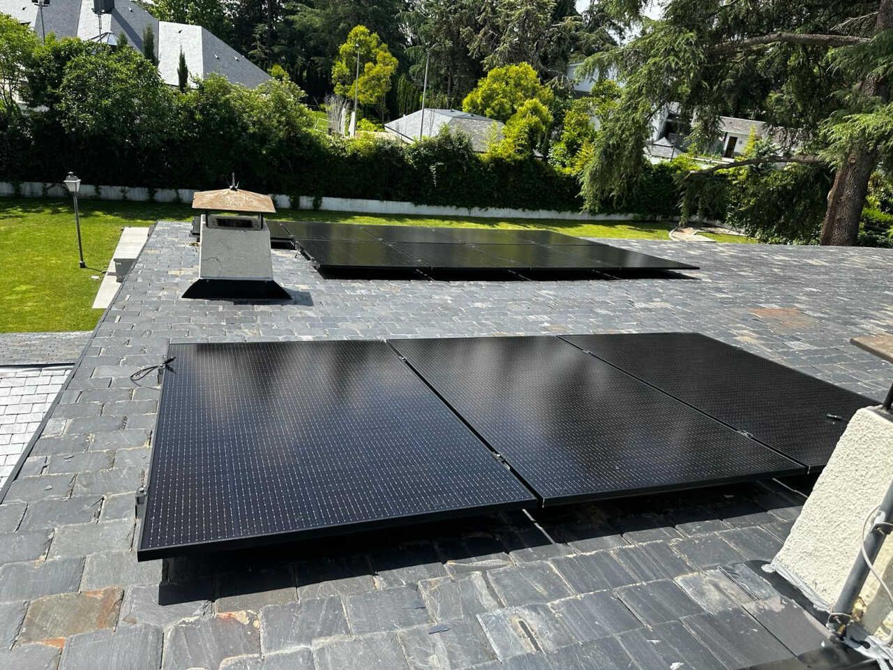Tres paneles solares están ubicados encima de un patio de ladrillo.
