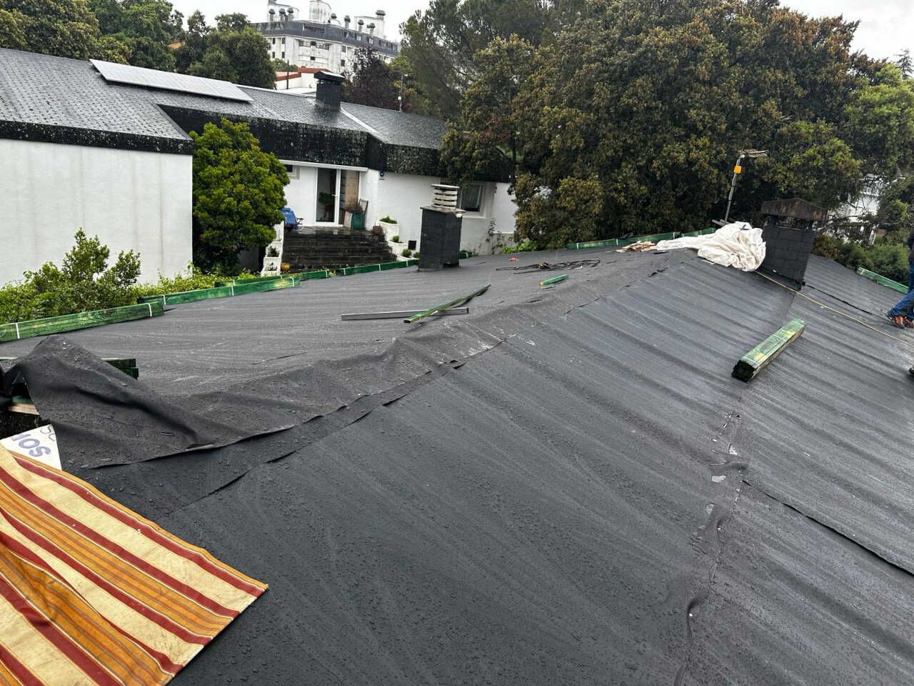Una persona está trabajando en el tejado de una casa.