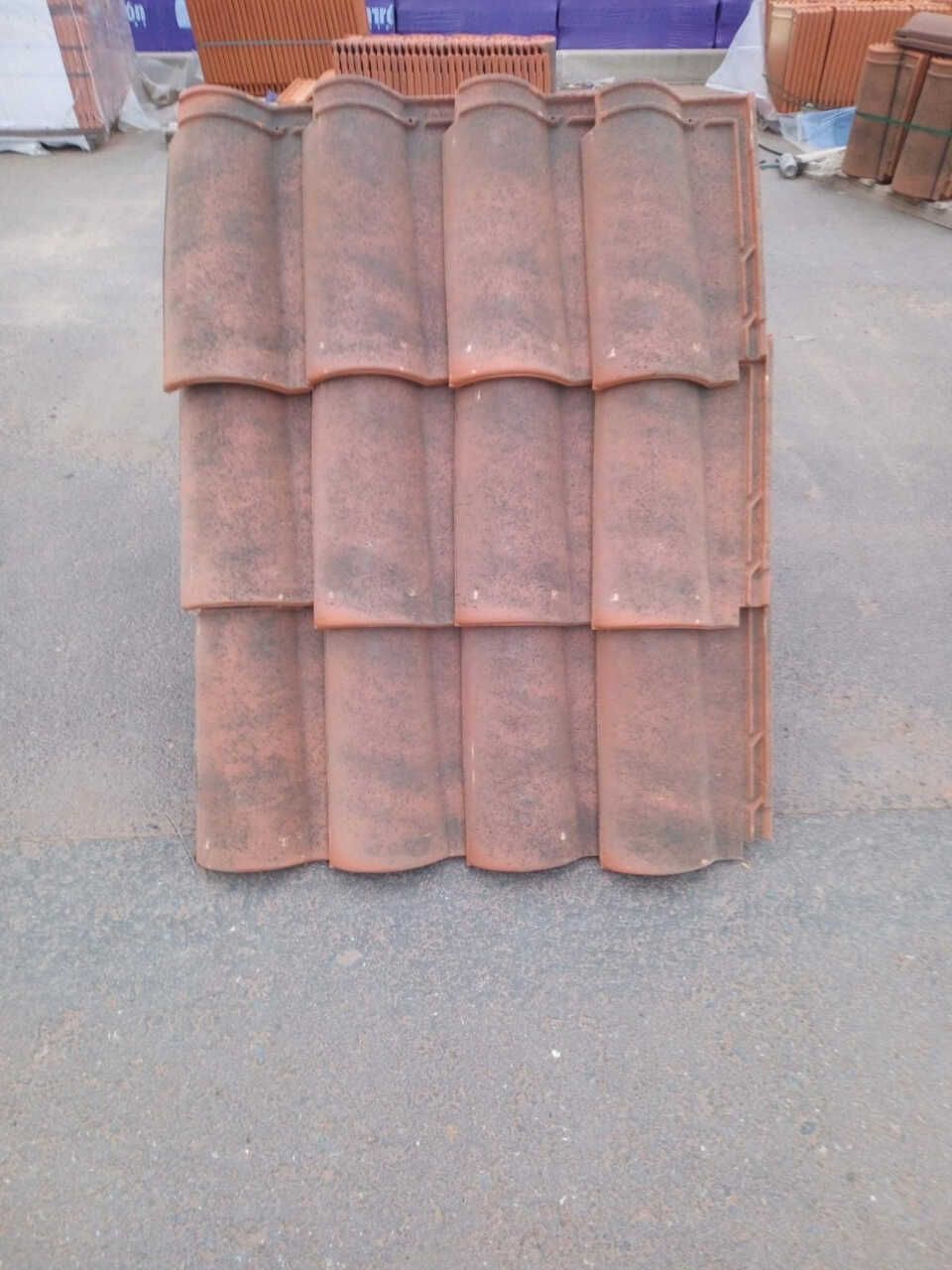 Una pila de tejas rojas colocadas una encima de otra en el suelo.