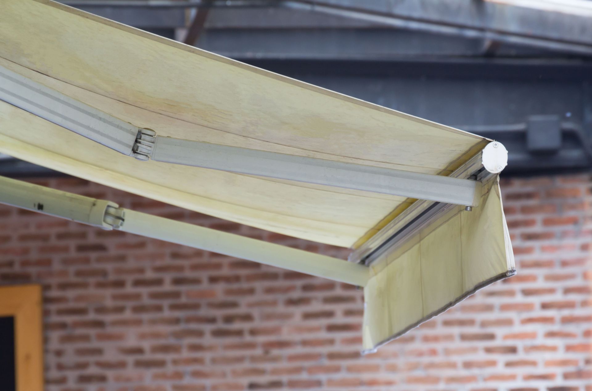 Un toldo blanco cuelga del techo de un edificio de ladrillo.