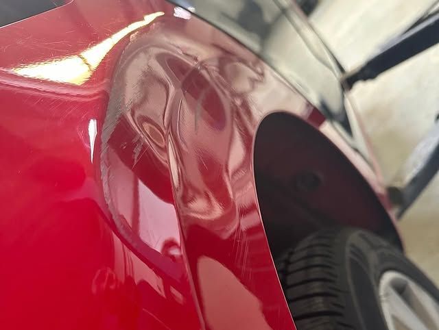 Verbeultes, rotes Auto von hinten