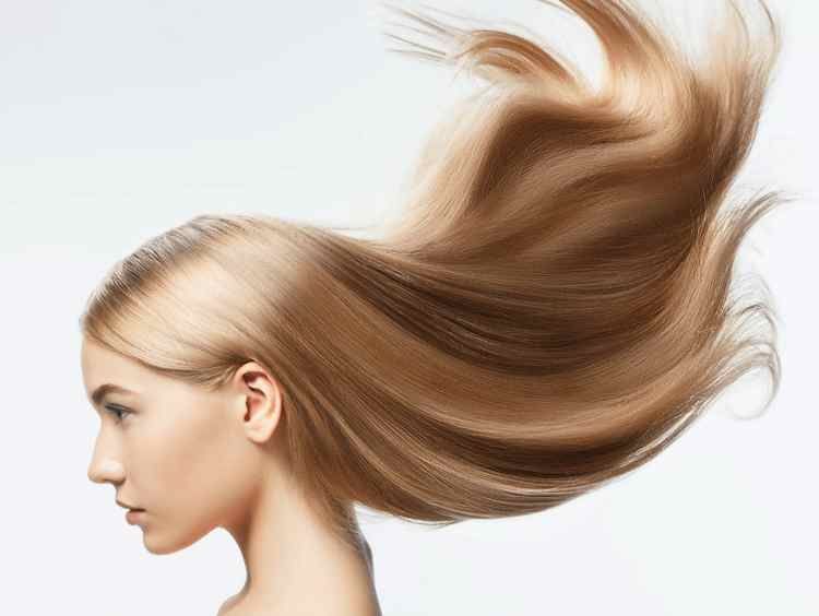 Una mujer con cabello largo y rubio ondeando al viento.