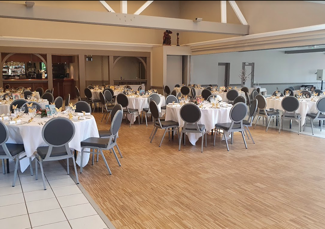 Intérieur de la salle du Chèvrefeuille avec des tables de réception.