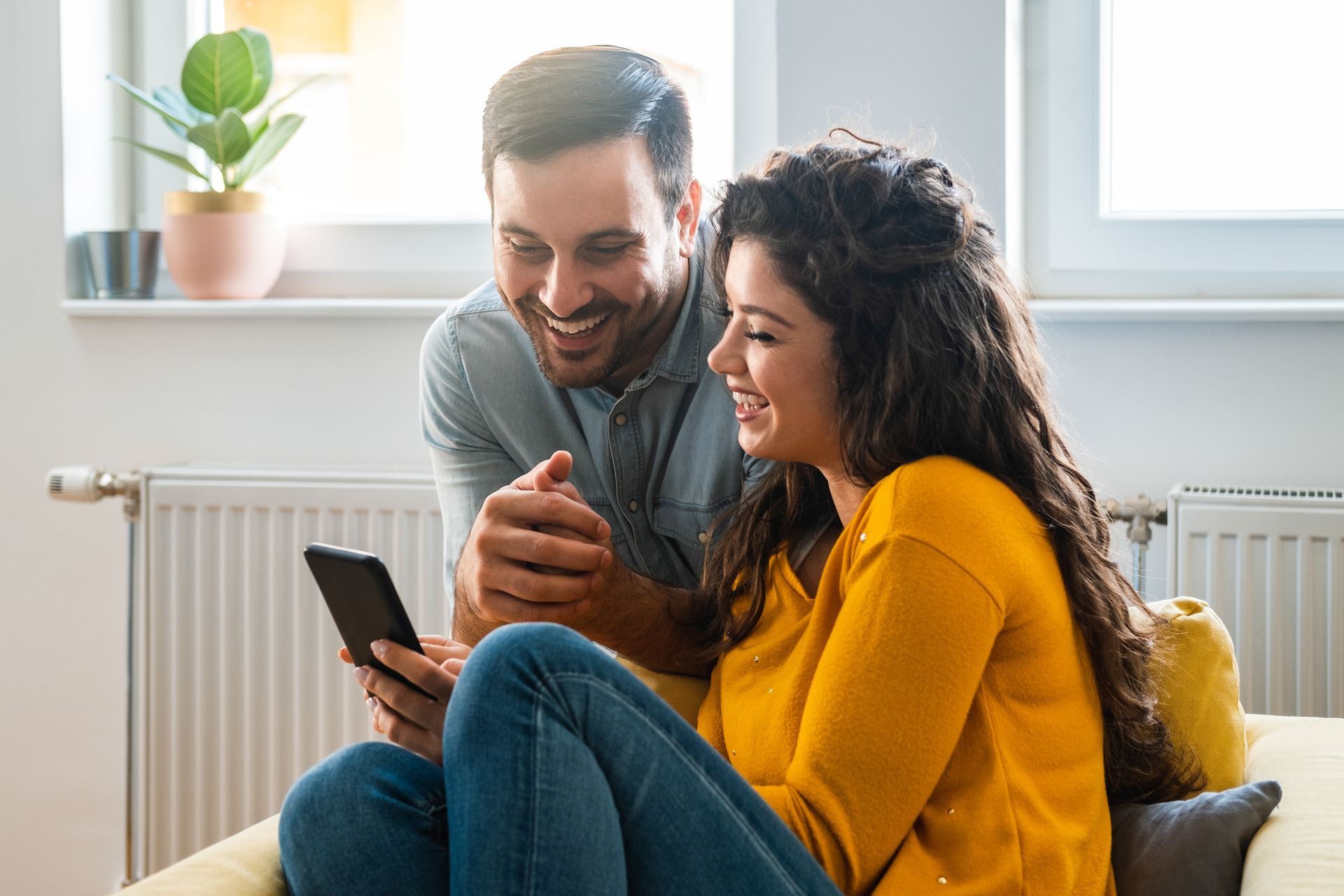 Jeune couple dans un canapé avec un téléphone.