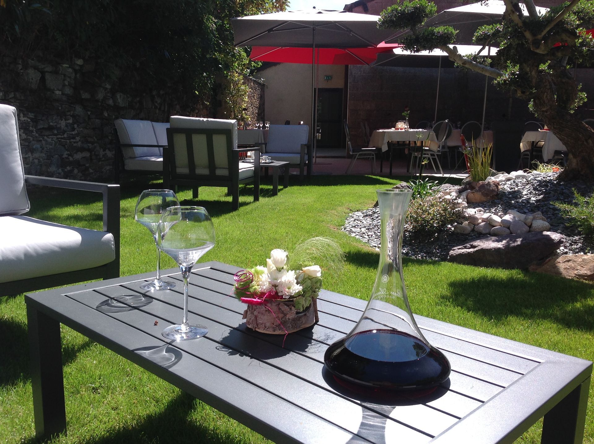 Cour intérieure du restaurant La Gibecière avec une carafe de vin au premier plan.