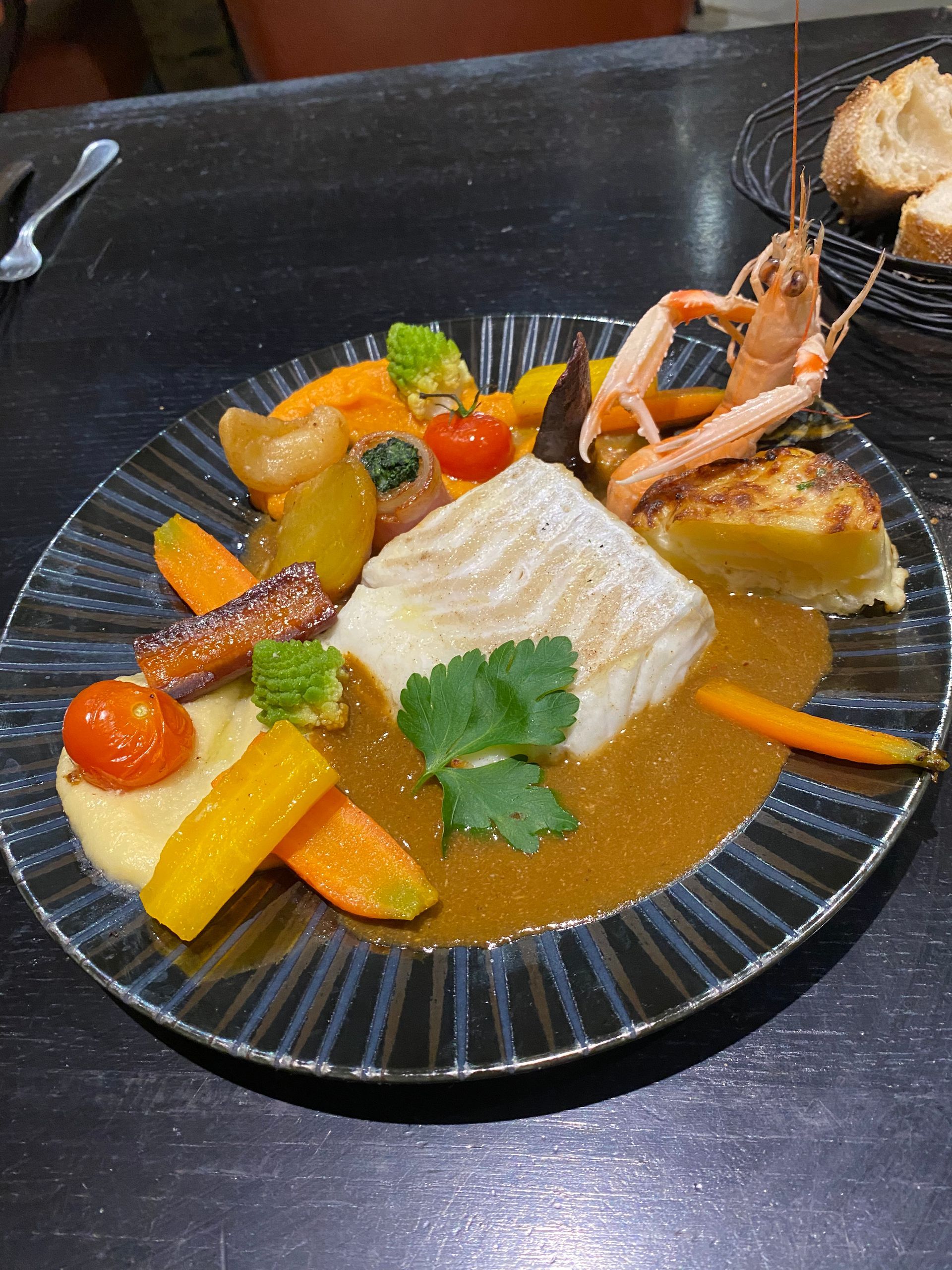 Assiette de poisson en sauce avec des légumes.