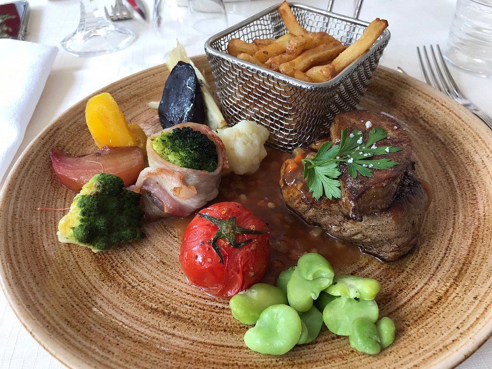 Assiettes de viandes, légumes et frites.
