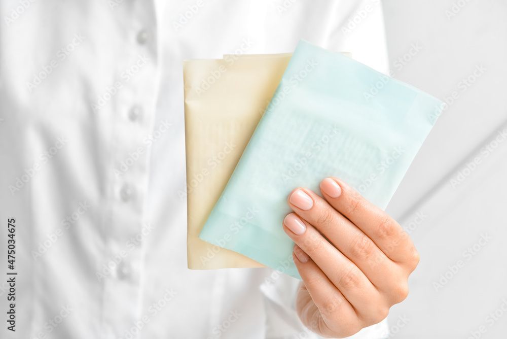 Una donna tiene tra le mani due fogli di carta.