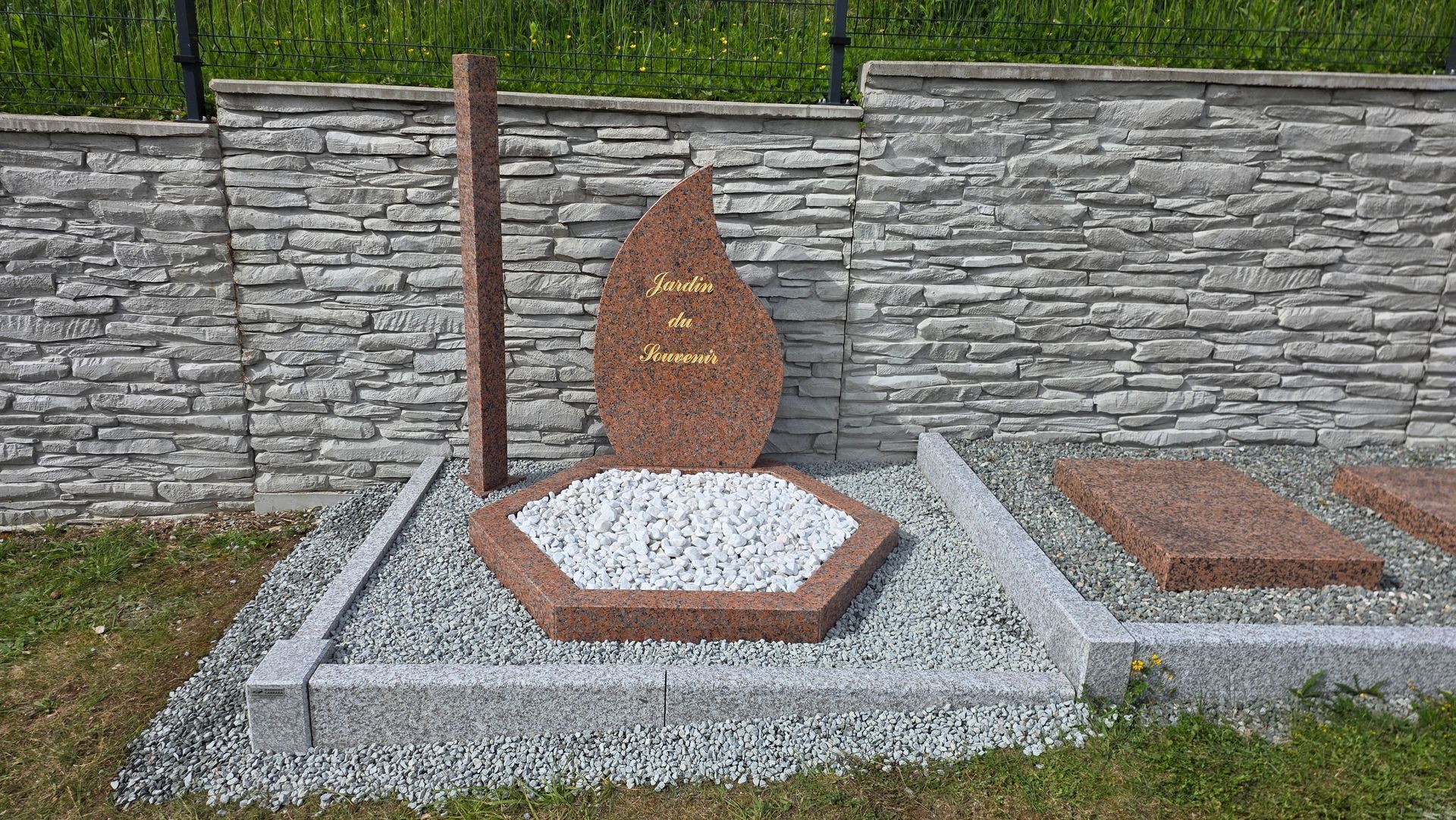 Jardin de sculptures en pierre avec une sculpture en granit en forme de larme.