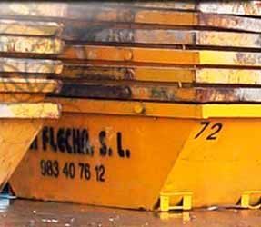 Un contenedor de basura amarillo con el número 72 está apilado uno encima del otro.