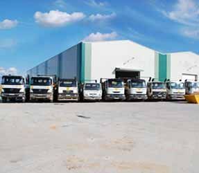 Una fila de camiones están estacionados frente a un edificio.