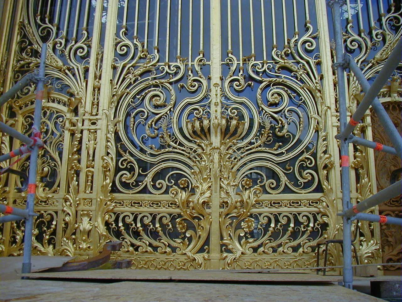 Travaux sur grille de sécurité dorée après décapage