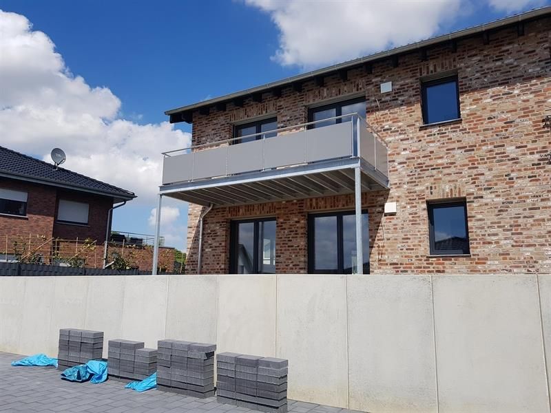 Neugebautes Haus mit Mauer und Balkon