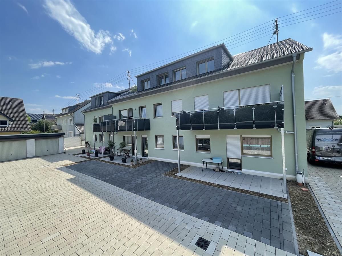 Ein grünes Gebäude mit einem davor geparkten schwarzen Lieferwagen