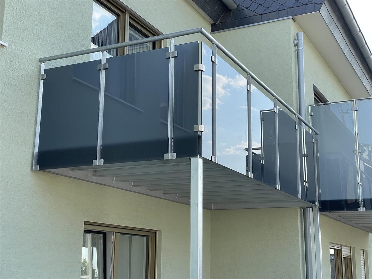 Ein Balkon an der Seite eines Gebäudes mit einem Edelstahlgeländer