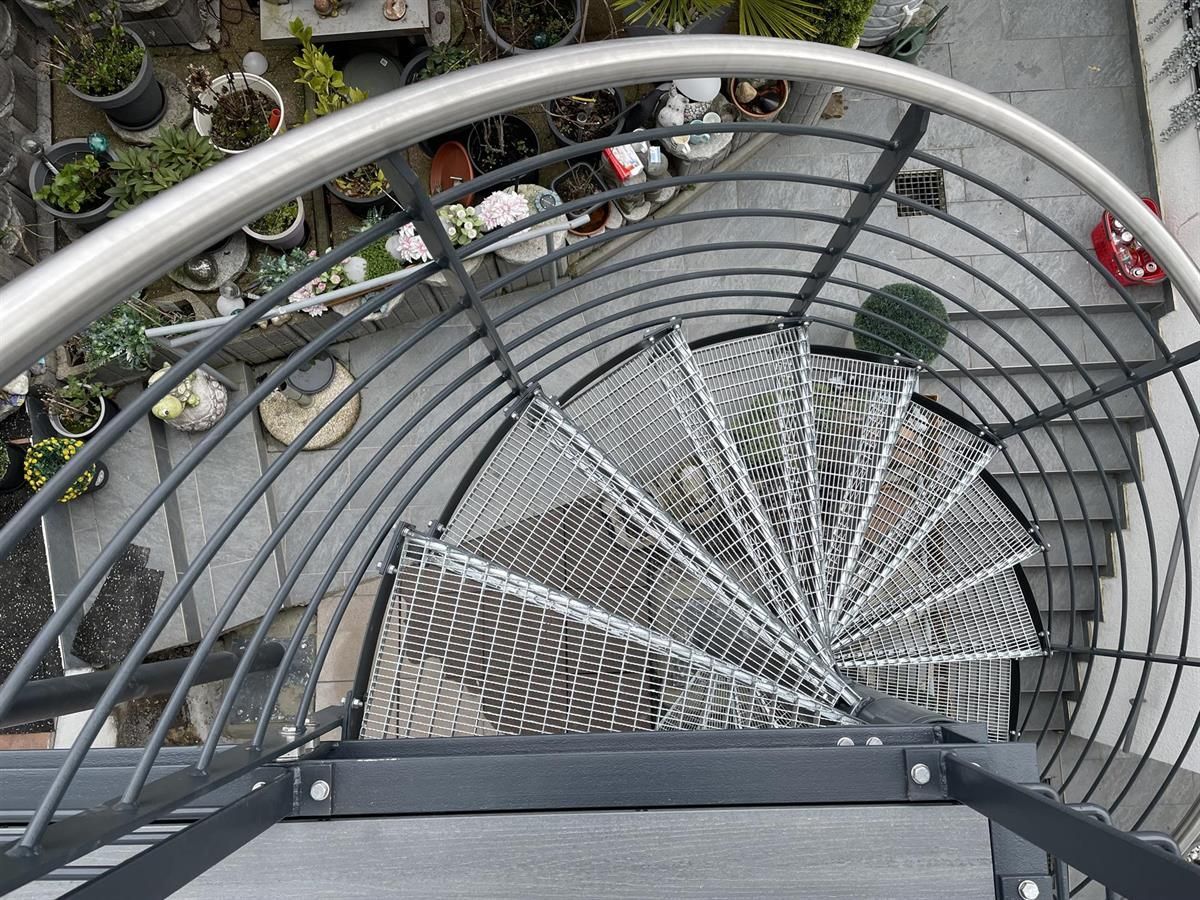 Eine Luftaufnahme einer Wendeltreppe, umgeben von Topfpflanzen